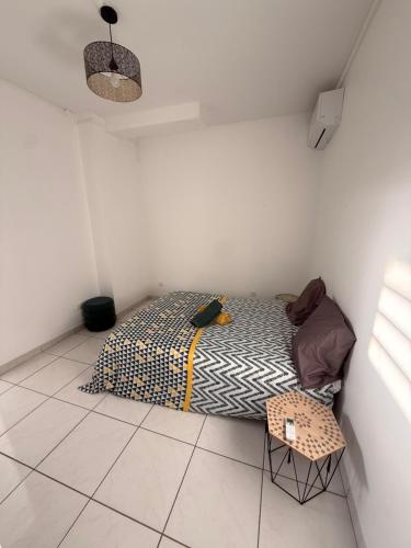 a small bedroom with a bed in a room at Charmant T2 sur le robert in Le Robert