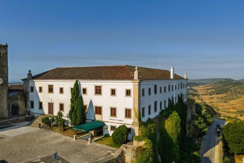 a large white building with a bench in front of it at Pousada Castelo de Palmela in Palmela