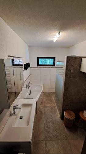a bathroom with a sink and a bath tub at Gästehaus FaRitz in Knittelfeld