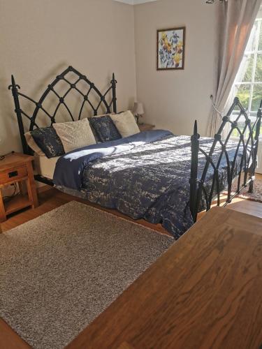 a bedroom with a large bed with a wooden frame at Le Petit Verger in Grumesnil