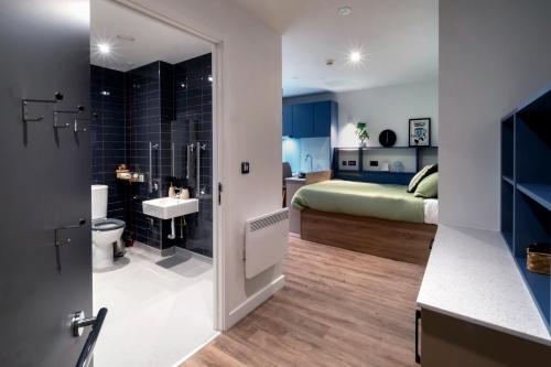 a bathroom with a sink and a toilet and a bedroom at The Artisan - City Centre in Dublin