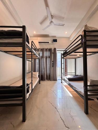 a room with three bunk beds and a ceiling at OLT Hostel Rishikesh in Rishīkesh