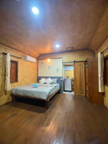 a large bedroom with a bed and a wooden floor at Panan Homestay Kohpu in Ban Na