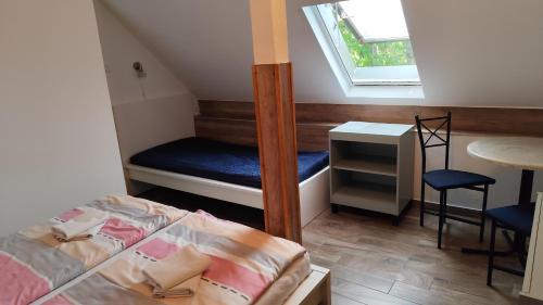 a small room with a bed and a table and a window at Arcadia Guesthouse in Ábrahámhegy