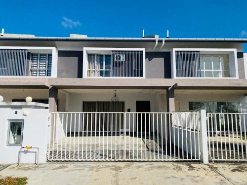 a house with a white fence in front of it at Hanah Home Pagoh in Pagoh