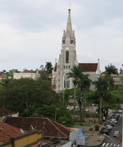 a church with a clock tower in a city at Hotel Jaú by Easy Hotéis in Jaú
