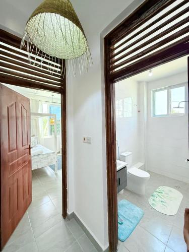 a bathroom with a toilet and a large doorway at Malindi Modern 2BR Near the Beach With a Private Pool in Malindi