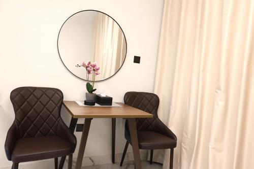a table with two chairs and a mirror at Chic Studio near Cleveland by Central Stay in Abu Dhabi