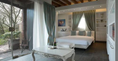 a bedroom with a bed and a table and a window at Boutique Hotel Westerlee in Westerlee