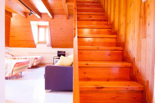 a staircase in a living room with a blue couch at Ostau dera nheu in Les