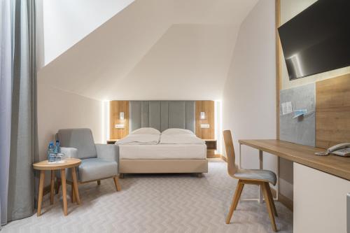 a bedroom with a bed and a chair and a table at Platino Mare Resort & Spa in Świnoujście