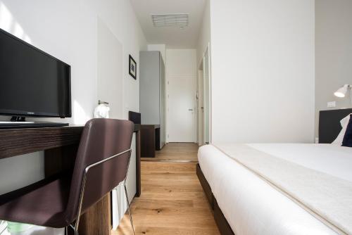 a bedroom with a bed and a flat screen tv at 7Florence in Florence