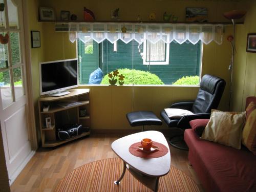 a living room with a couch and chairs and a television at Apartment Haus Jule by Interhome in Wervershoof