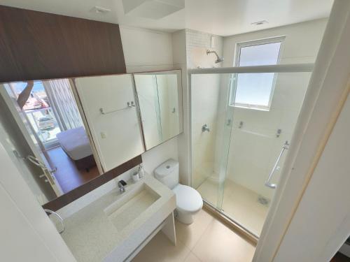 a bathroom with a toilet and a shower and a sink at Excelente Apto no condomínio Boulevard in Bombinhas