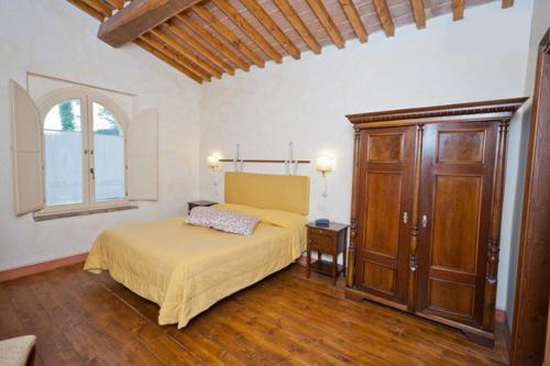 a bedroom with a bed and a dresser and a window at La Locanda del Borgo in Pietralunga