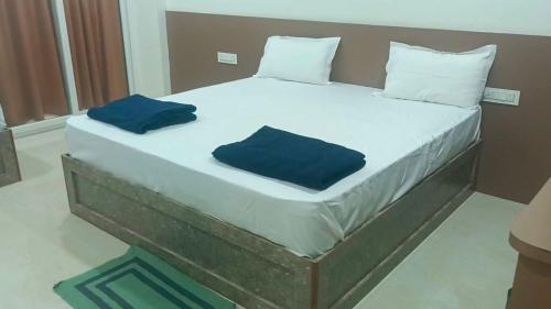 a large bed with two blue pillows on it at Hotel O V GUEST INN in Bhattiprolu