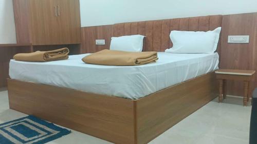 a large bed with white sheets and pillows on it at Hotel O V GUEST INN in Bhattiprolu