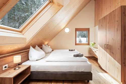 ein Schlafzimmer mit einem Bett und einem großen Fenster in der Unterkunft Chalet Modriach - Private Sauna & Whirlpool in Modriach