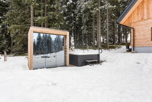 eine Tür im Schnee neben einem Gebäude in der Unterkunft Chalet Modriach - Private Sauna & Whirlpool in Modriach