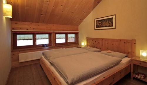 a bedroom with a large bed in a cabin at Villa Natur in Schröcken