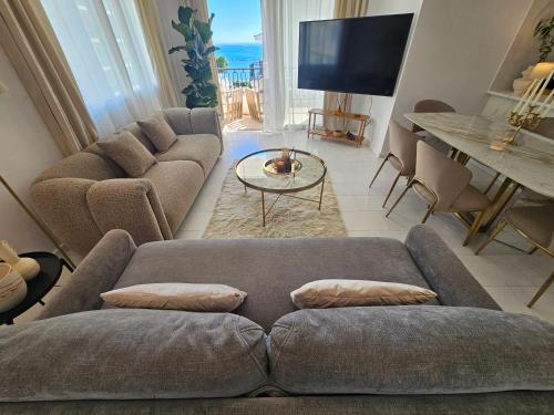 a living room with a couch and a tv at Beach Front View Apartment Sea Pool & Prime Location in Limassol