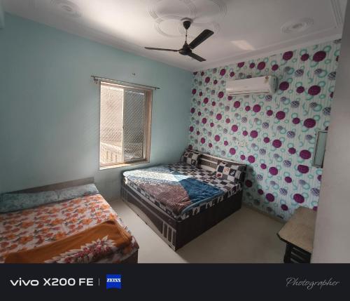 a bedroom with two beds and a ceiling fan at Hotel karishna palace in Rīngas