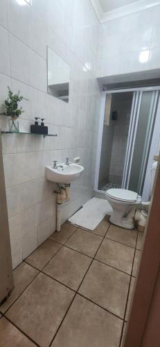 a bathroom with a sink and a toilet at RoomsAtRoseAve19 in Kuruman