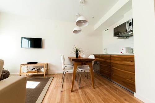 a kitchen and living room with a wooden table and chairs at El Mirador Del Alcazar in Segovia