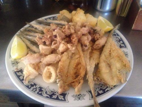 a plate of food with fish and shrimp on it at Hostal San Luis in Almodóvar del Río