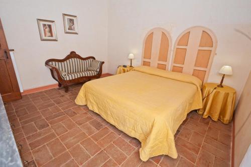 a bedroom with a yellow bed and a chair at La Locanda del Borgo in Pietralunga