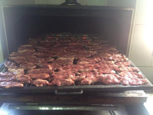 a large group of meat cooking in an oven at Hostal San Luis in Almodóvar del Río