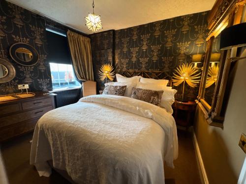 a bedroom with a bed with a white comforter at Meifod country house hotel in Caernarfon