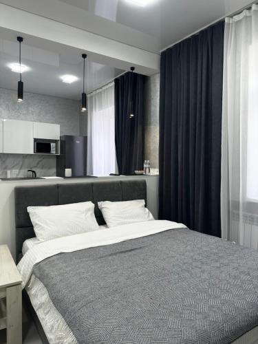 a bedroom with a large bed and a kitchen at Apartments Velora in Kryvyi Rih