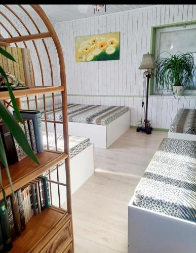 a room with benches and books on the wall at Šilas in Degučiai