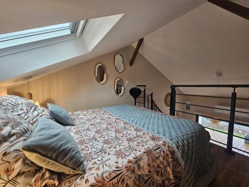 a bedroom with a bed with pillows and a window at L'arbre de soie - l'acacia in Vouillé