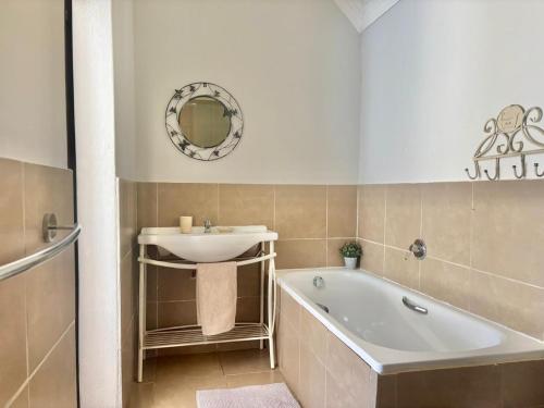 a bathroom with a bath tub and a sink at Ledges Retreat in Bergville