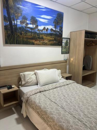 a bedroom with a bed and a painting on the wall at Aparthotel Maison Suisse in Asunción
