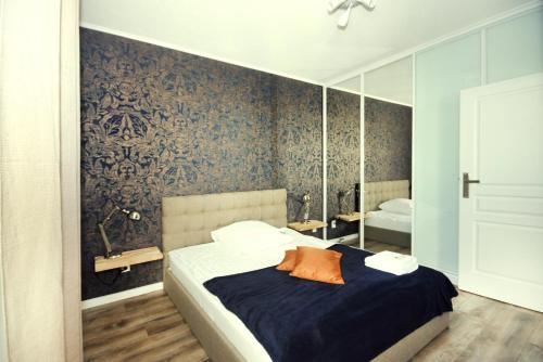 a bedroom with a bed and a mirror at Livin Apartments Santocka in Szczecin
