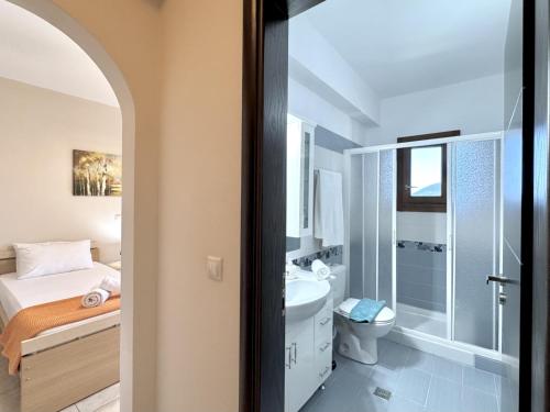 a bathroom with a bed and a toilet and a sink at Villa Vassilis Fiscardo Kefalonia in Katsaráta