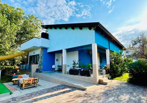 a blue house with a table and a patio at B&B Oasi al Mare in Agropoli