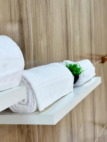 a stack of towels on a shelf in a bathroom at Apartamento juçara Lençóis in Barreirinhas