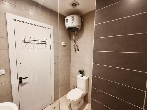 a small bathroom with a toilet and a shower at View Pool Apartment, Two Rooms in El Gouna
