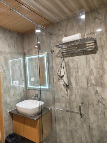 a bathroom with a sink and a glass shower at Hotel Heritage Inn in Samastīpur