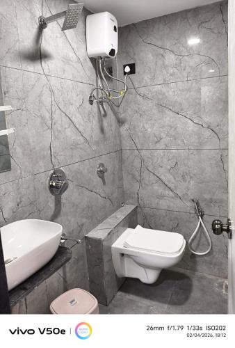 a bathroom with a toilet and a sink at Hotel 7 CR in Ahmedabad