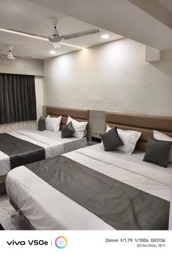 a hotel room with two beds in a room at Hotel 7 CR in Ahmedabad