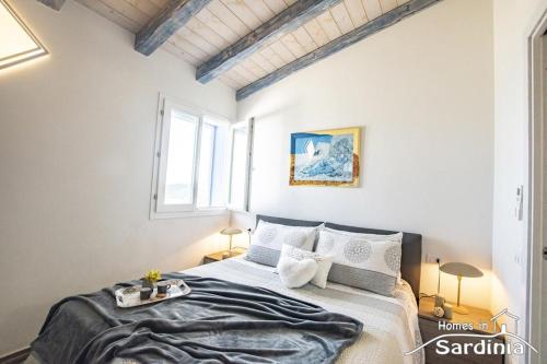 a bedroom with a bed and two windows at Tra blu e celeste in Castelsardo