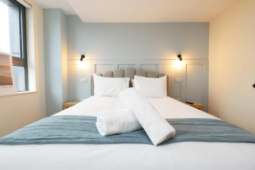 a bedroom with a large white bed with white pillows at The Swansea Central Hall 1 Bed Room Apartment in Swansea