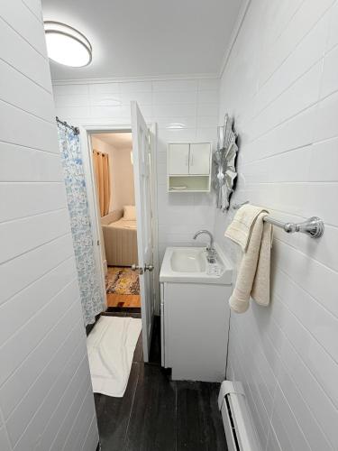 a small white bathroom with a sink and a room at Comfortable 2BR & 2 Bath Apt in Downtown NYC in New York