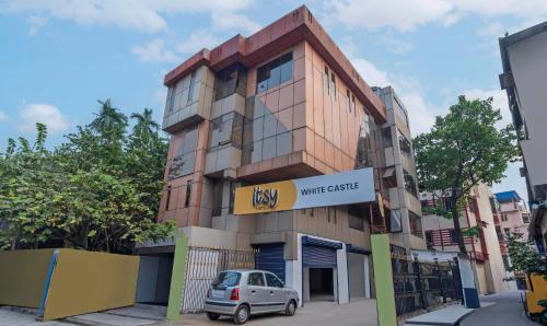 a building with a car parked in front of it at Itsy Hotels White Castle in Kolkata