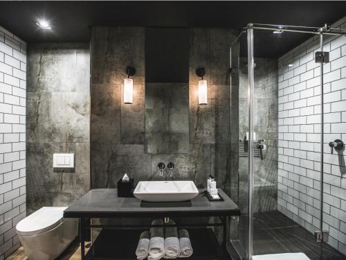 a bathroom with a sink and a shower at Century City Hotel Urban Square in Cape Town